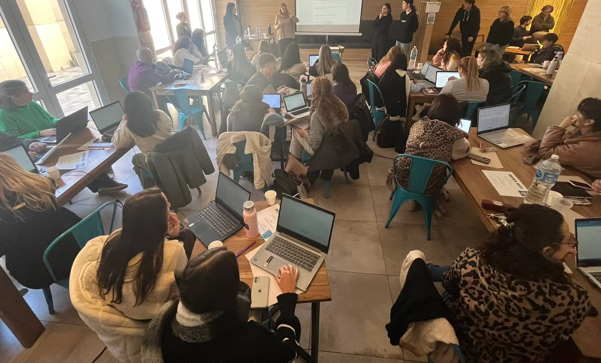 Docentes trabajando en un taller con laptops